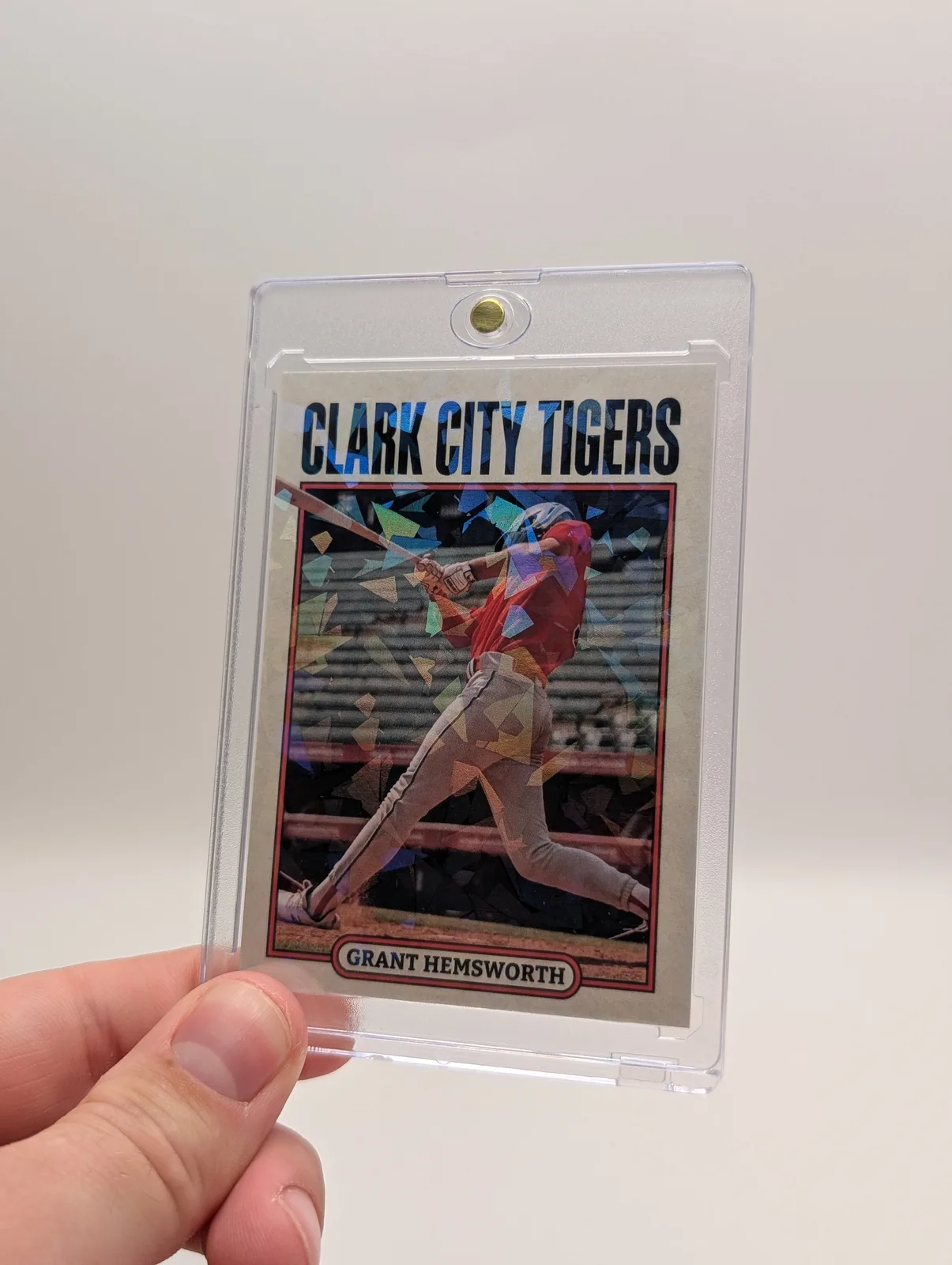 Baseball card held in a clear magnetic case, with a reflective pattern visible around the player